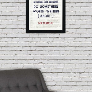 May include: A black framed print with a white background and a quote by Ben Franklin that reads "Either write something worth reading or do something worth writing about."