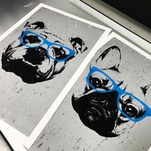 May include: Two black and white illustrations of dogs wearing blue glasses on a gray background.