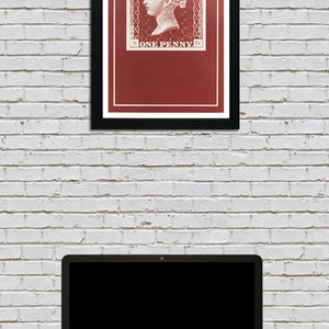 May include: A framed print of a vintage postage stamp featuring a portrait of Queen Victoria. The stamp is red with white lettering that reads "POSTAGE" and "ONE PENNY".
