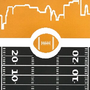 May include: A black and white illustration of a football field with the numbers 10, 20, 10, and 20 printed on the field. A white circle with a football inside is in the center of the image. The background is orange with a white cityscape.