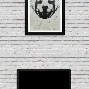Puede incluir: Ilustraci&oacute;n en blanco y negro de la cara de un perro con fondo blanco. El perro est&aacute; sonriendo con la lengua fuera. La ilustraci&oacute;n est&aacute; enmarcada en un marco negro y colgada en una pared de ladrillo blanco.