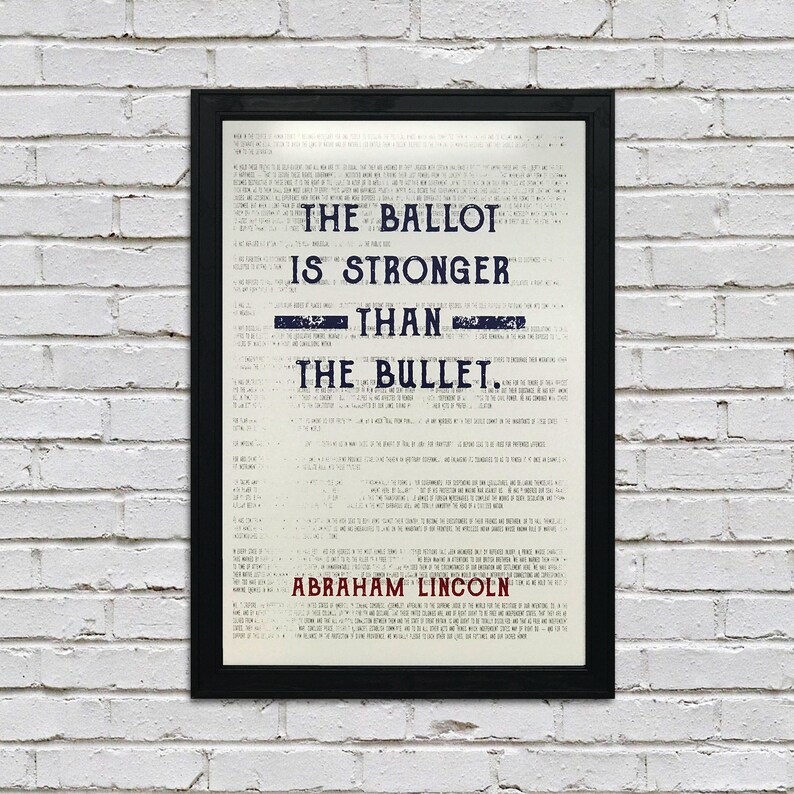 May include: A black framed print with a white background and blue text. The text reads "The ballot is stronger than the bullet. Abraham Lincoln".