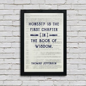 May include: A black framed print with a white background and blue text. The text reads "Honesty is the first chapter [in] the book of wisdom. Thomas Jefferson."