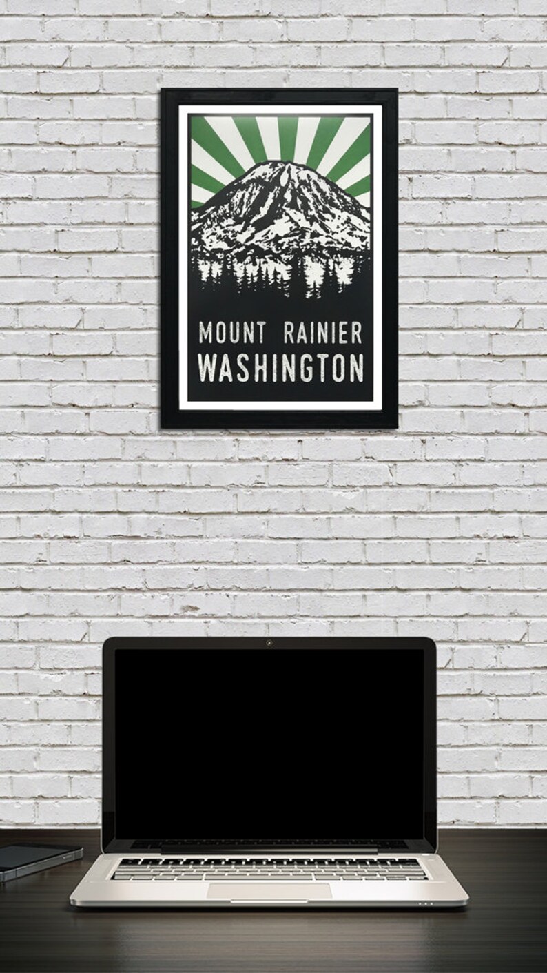 May include: A black and white illustration of Mount Rainier, a mountain in Washington state, with green rays emanating from the peak. The text "MOUNT RAINIER WASHINGTON" is below the mountain.