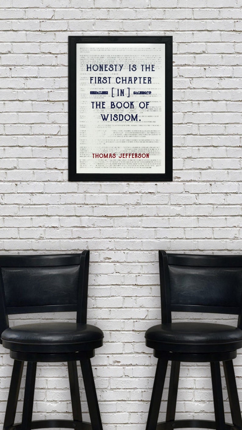 May include: A framed print with the quote "HONESTY IS THE FIRST CHAPTER [IN] THE BOOK OF WISDOM" by Thomas Jefferson. The print is in a black frame, set against a white brick wall. Two black bar stools are in the foreground.