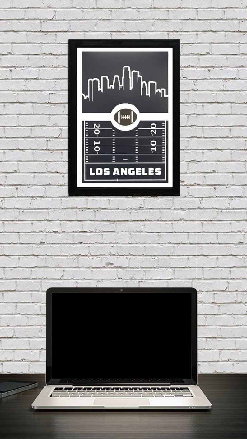 May include: Black and white print of the Los Angeles skyline with a football field graphic and the text "Los Angeles" at the bottom.