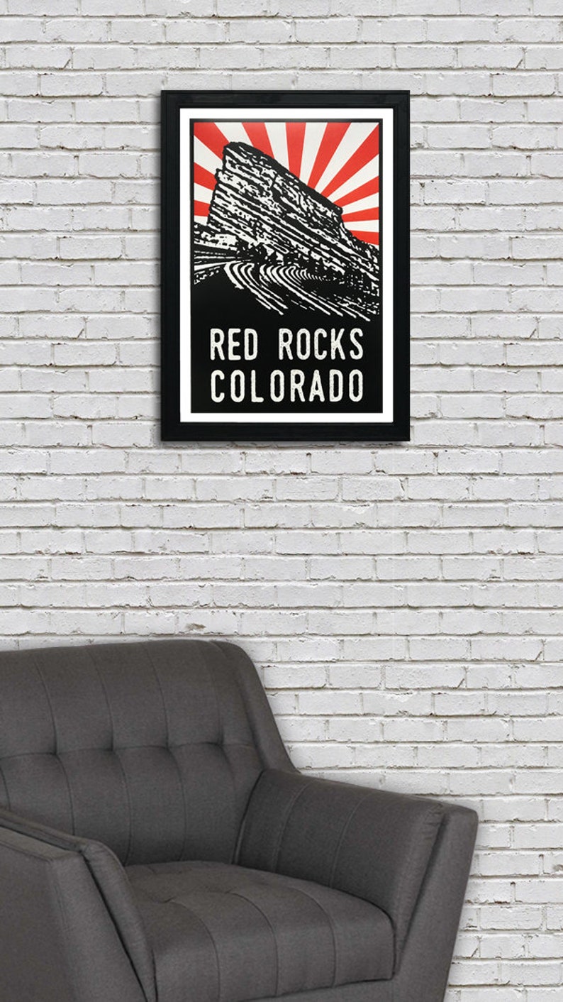 K&ouml;nnte beinhalten: Eine Schwarzwei&szlig;illustration des Red Rocks Amphitheaters in Morrison, Colorado. Die Illustration zeigt ein rotes und wei&szlig;es Sonnenstrahlen-Design hinter der Felsformation. Der Text "RED ROCKS COLORADO" ist unter der Illustration gedruckt.