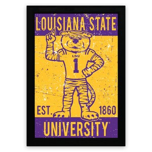 May include: Framed print with the Louisiana State University tiger mascot in a number 1 jersey. The image has a distressed, vintage style, with the text "Louisiana State University" and "Est. 1860". The colour scheme is purple and gold.