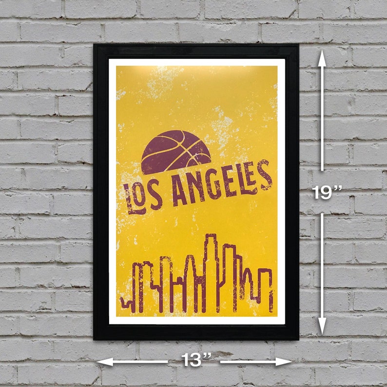May include: Framed poster with a yellow background featuring a basketball and the text "LOS ANGELES" in a distressed font. The poster also includes a skyline silhouette. The framed poster measures 19 inches high and 13 inches wide.