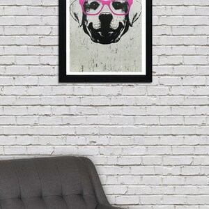 May include: A black and white illustration of a dog wearing pink glasses. The dog is looking directly at the viewer. The illustration is framed in a black frame.