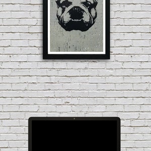 Puede incluir: Una ilustraci&oacute;n en blanco y negro de la cara de un bulldog en un marco negro colgado en una pared de ladrillo blanco sobre un ordenador port&aacute;til.