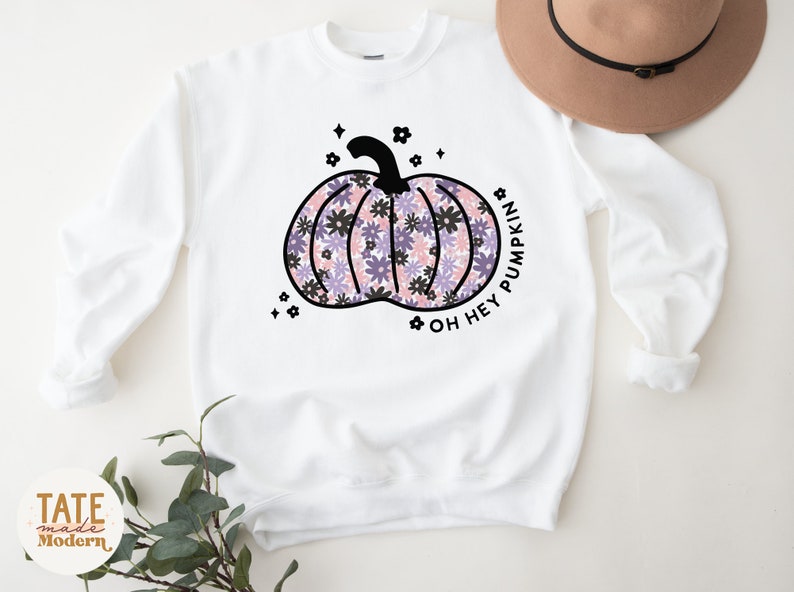 May include: White sweatshirt with a black floral pumpkin design and the text "Oh Hey Pumpkin".