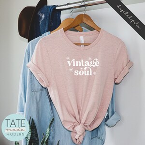 May include: A pink t-shirt with the text "vintage soul" in white lettering with stars around the text.