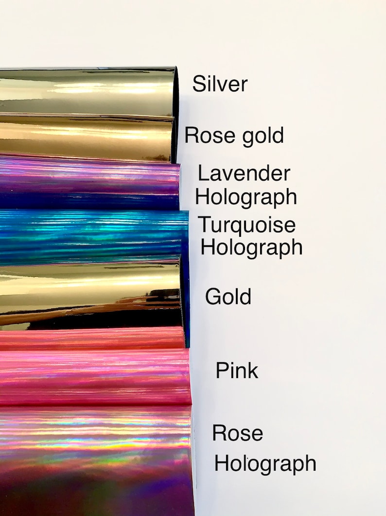 Op de afbeelding: Een close-up van acht verschillende gekleurde vinyl vellen. De kleuren zijn zilver, ros&eacute; goud, holografisch lavendel, holografisch turquoise, goud, roze en holografisch roze.
