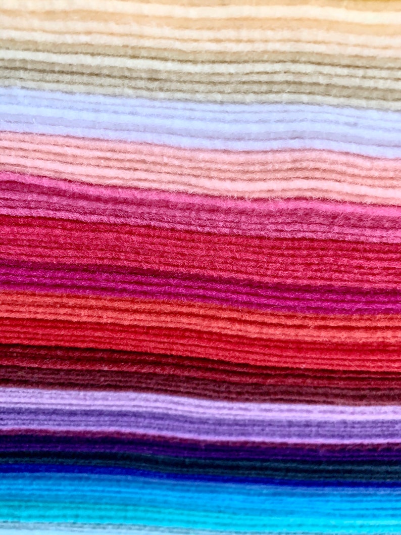 May include: A stack of felt fabric in various colors, including beige, light blue, pink, red, purple, blue, and turquoise.