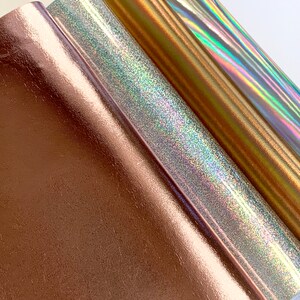 Op de afbeelding: Drie rollen metallic vinyl in ros&eacute; goud, zilver en goud. Het zilveren vinyl heeft een holografische afwerking.