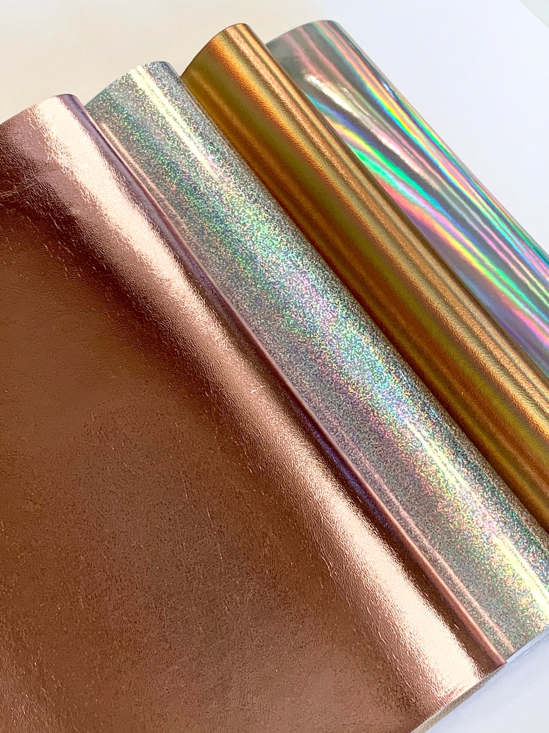 Op de afbeelding: Drie rollen metallic vinyl in ros&eacute; goud, zilver en goud. Het zilveren vinyl heeft een holografische afwerking.