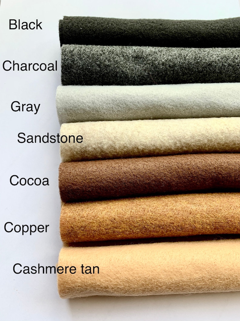 May include: A close-up of eight different colors of felt fabric swatches. The colors are black, charcoal, gray, sandstone, cocoa, copper, cashmere tan, and white.