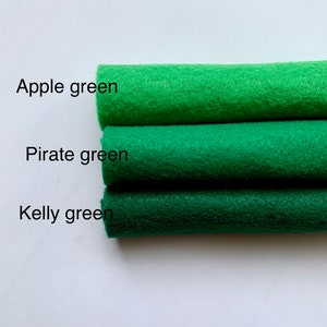 May include: Three rolls of felt fabric in different shades of green. The top roll is labeled "Apple green", the middle roll is labeled "Pirate green", and the bottom roll is labeled "Kelly green".