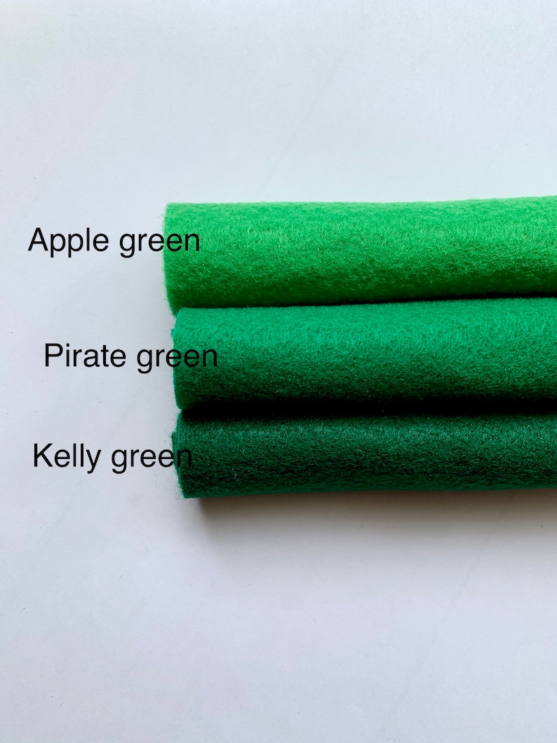 May include: Three rolls of felt fabric in different shades of green. The top roll is labeled "Apple green", the middle roll is labeled "Pirate green", and the bottom roll is labeled "Kelly green".
