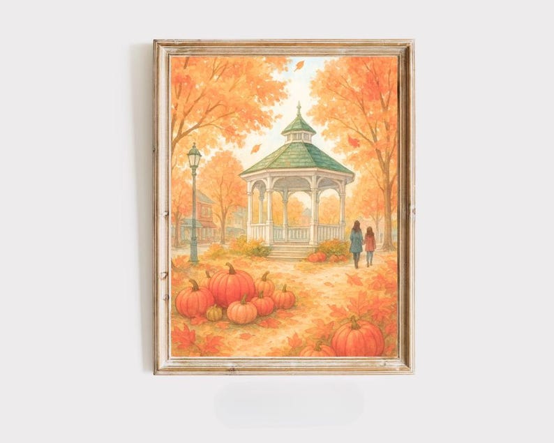 May include: A framed watercolour print of an autumnal scene. The artwork shows a gazebo with a green roof, surrounded by orange trees and pumpkins. Two figures walk along a path. The overall theme is autumn and harvest.