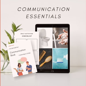 May include: A white tablet displaying a checklist with images of a toilet, hands washing, a hairbrush, and a toothbrush. The tablet is on a white surface with a white and green plant in a clear vase. The text on the tablet reads "DAILY ACTIVITIES CHECKLIST". The text on the book reads "Communication Book Connecting is Living".