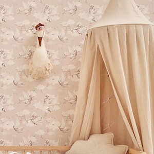 May include: A white canopy bed with a pink and white floral wallpaper. The bed has a white stuffed animal and a white pillow.