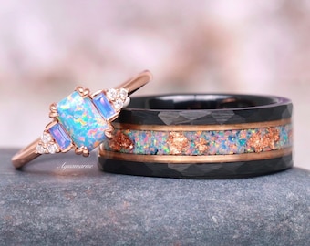 Peut inclure: Une paire d'alliances de mariage comprenant une bague en or rose avec une pierre précieuse en opale bleue et blanche et une bague noire avec une incrustation de cuivre et d'opale.