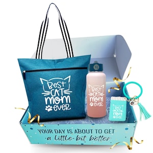 May include: A blue tote bag with the text "Best Cat Mom Ever" in white, a pink water bottle with the same text, a small blue keychain with the same text, and a blue box with the text "Your day is about to get a little bit better".