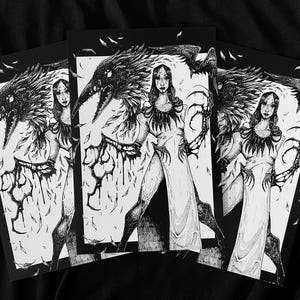May include: A black and white ink illustration print featuring a central figure in a long dress with clawed hands and a large raven perched on their shoulder. The artwork is detailed with feathers, dark textures, and a stark contrast between light and shadow.