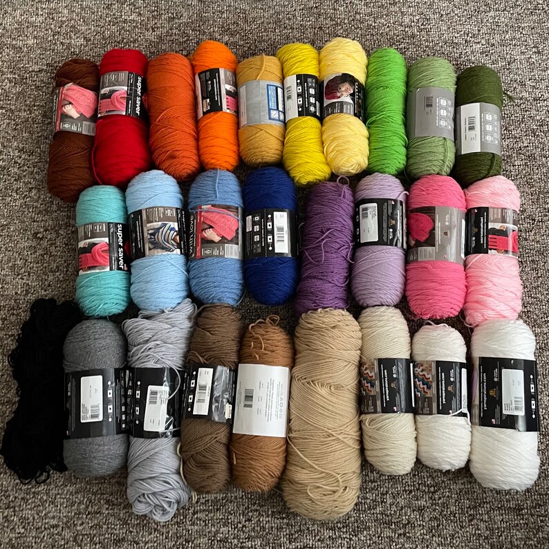 May include: A collection of 20 yarn skeins in various colours, including black, white, grey, brown, blue, purple, pink, green, and yellow. The yarn is arranged in two rows, with the skeins in each row alternating colours.
