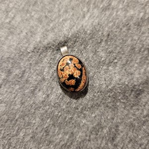 Small unmarked sterling silver and rhodonite oval shaped pendant