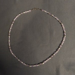 Rounded amethyst and freshwater pearl necklace with sterling silver bead accents and hook closure.