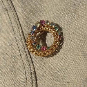 Linked hoops brooch with multicolor rhinestones and uranium glass