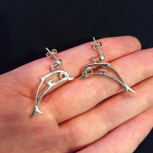 Sterling silver stylized dolphin earrings, wire cutout style.