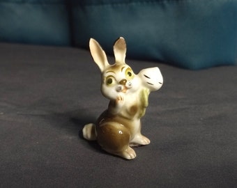 Tiny porcelain brown rabbit with white radish or turnip figurine, cute expression, cartoony and stylized collectible