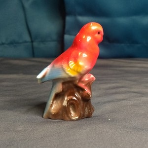 Red parrot or parakeet figurine with blue wing tips