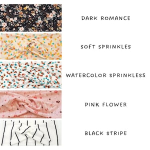 May include: Five fabric headbands in various designs. Patterns include a dark floral, colourful sprinkles, watercolour sprinkles, pink flowers, and black and white stripes. Each headband has its pattern name printed alongside.