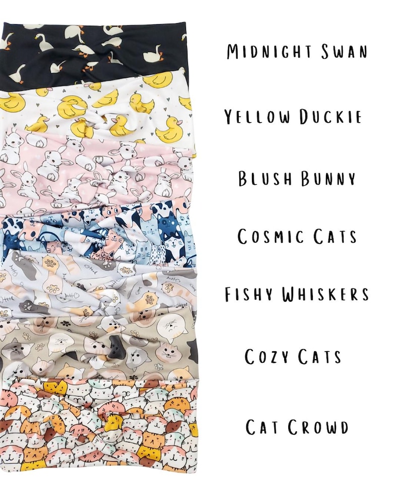 May include: A stack of seven fabric headbands with various patterns. Designs include swans, ducks, bunnies, cats, and fish. Text on the right reads "Midnight Swan", "Yellow Duckie", "Blush Bunny", "Cosmic Cats", "Fishy Whiskers", "Cozy Cats", and "Cat Crowd".