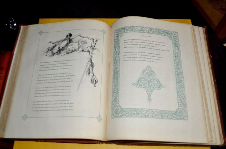 May include: An open book with aged pages, featuring detailed illustrations and text. The left page displays a banner with the word "The Founder" and a drawing of a figure. The right page has a decorative border and text.