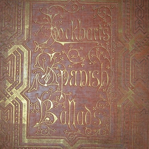 May include: Close-up of a vintage book cover with the title "Lockhart's Spanish Ballads" in gold lettering. The cover is a reddish-brown color with ornate gold geometric and floral designs.