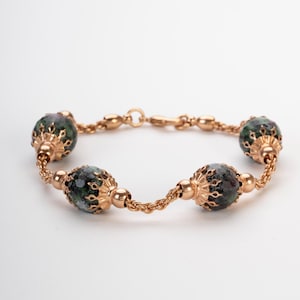 Peut inclure: Un bracelet en chaîne dorée avec quatre pierres ovales de couleur verte et noire serties d'or.