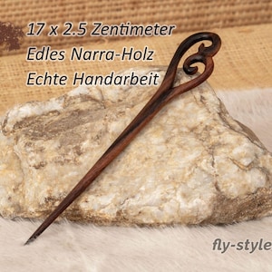 Può includere: Un bastoncino per capelli in legno marrone scuro con un design decorativo a spirale traforata sulla parte superiore. Il testo 17 x 2.5 Zentimeter, Edles Narra-Holz, Echte Handarbeit e fly-style è visibile. È realizzato in legno di Narra.