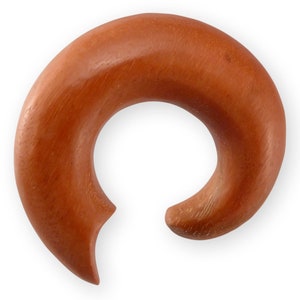 Könnte beinhalten: Ein spiralförmiger Ohrstecker aus rotbraunem Holz, eine Art Körperschmuck.