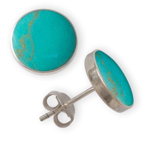 May include: A pair of silver earrings with turquoise stones. The stones are a light blue colour with brown veins.