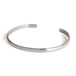 Op de afbeelding: Een zilveren armband met een geborstelde afwerking.