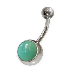 May include: A silver belly button ring with a turquoise gem.