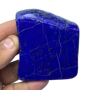 May include: A large, deep blue, irregularly shaped piece of lapis lazuli with white veins and gold flecks.