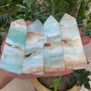 Puede incluir: Cuatro torres de cristal pulidas, azules y blancas, con una punta puntiaguda.