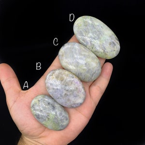Puede incluir: Cinco piedras lisas de forma ovalada en varios tonos de verde y gris. Las piedras están dispuestas en fila, con la piedra más grande en la parte superior y la más pequeña en la parte inferior. Las piedras están etiquetadas con las letras A a D.